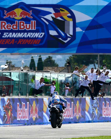 Álex Márquez rides down the pit lane as his team celebrates victory during the San Marino MotoGP World Championship at Misano, Italy, on September 14, 2025