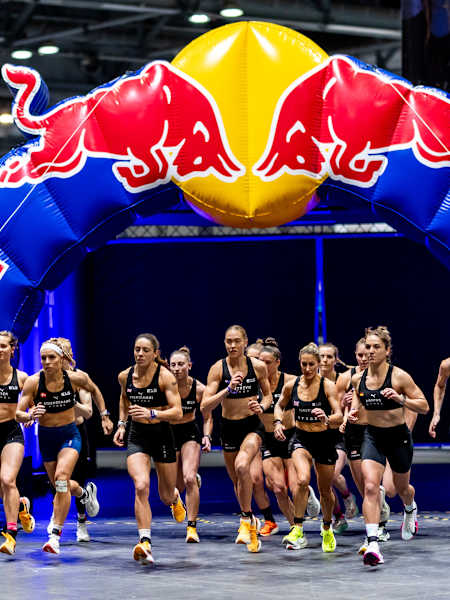 A group of female athletes run through an inflatable Red Bull arch at the HYROX Major in Hong Kong in November 2024.