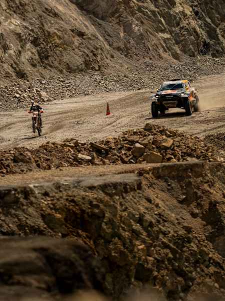 Carson Brown sur sa moto KTM 300 XC-W affronte Seth Quintero dans la voiture du Dakar Toyota GR DKR Hilux T1+ au sommet de l'Erzberg.