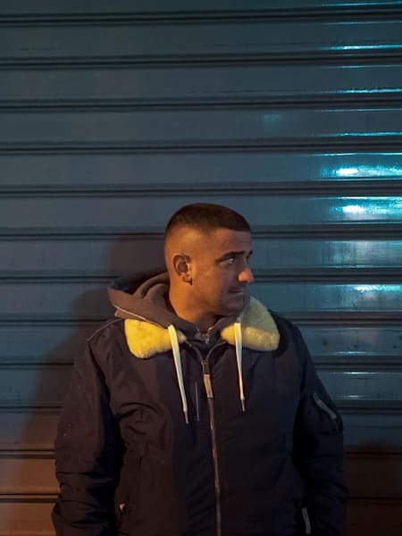 Der Rapper Haftbefehl steht vor einer Wand