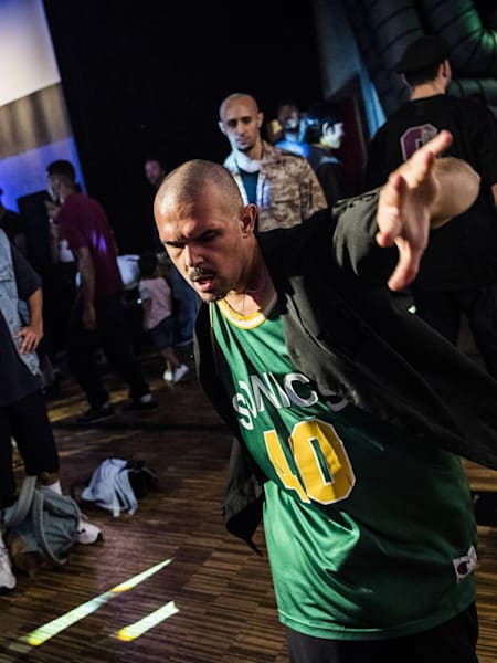 A B-Boy showing his top rocks in a cypher.