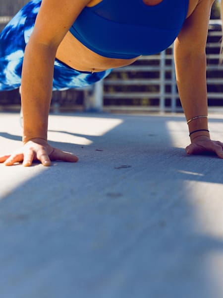 Women in blue sport legging does push-ups.