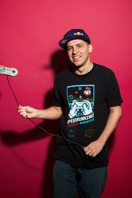 David "GrandPOObear" Hunt steht vor einem gefärbten Hintergrund