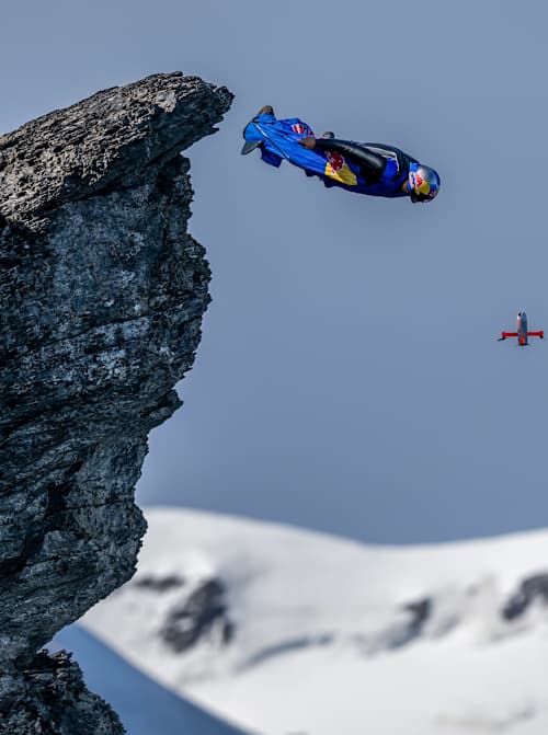 Peter Salzmann saute d'une corniche en wingsuit.