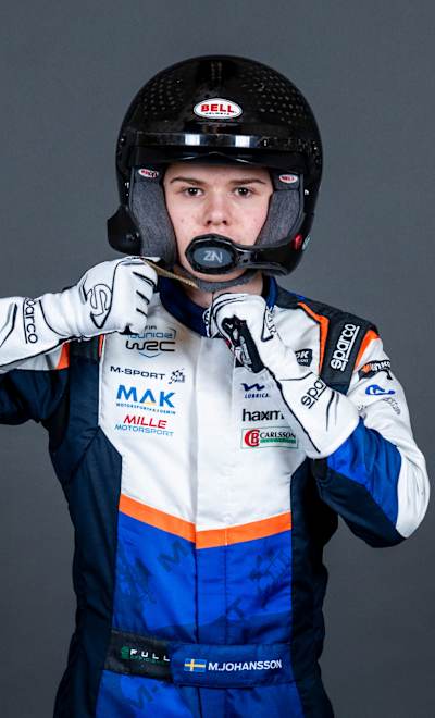 In 2025, Mille Johansson, a rally driver, poses in racing gear with Red Bull branding at the World Rally Championship event in Umea, Sweden
