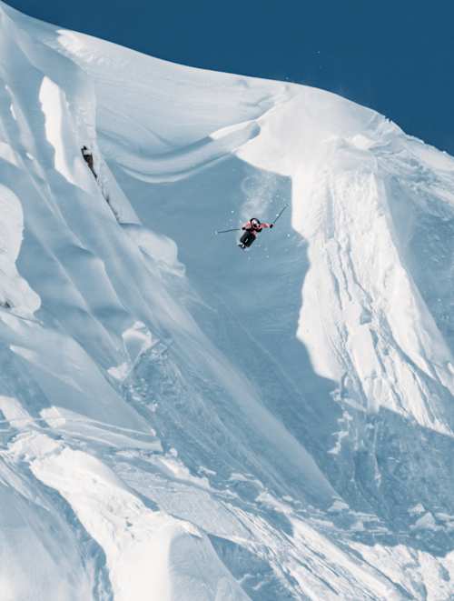 Max Palm launches off a massive Alaskan ridge at Red Bull Natural Selection in Alaska, United States on March 26, 2025, displaying daring freeride skiing against breathtaking snowy peaks