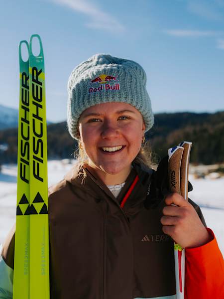 Biathletin Selina Grotian schaut lächelnd mit ihren Skiern in die Kamera.