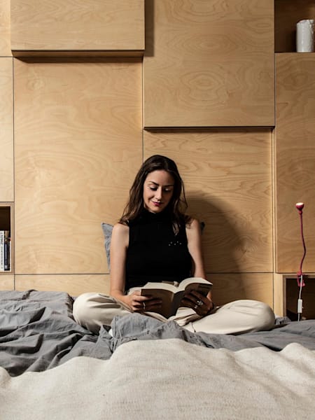 Naša spálňa v neutrálnych farbách a drevenou stenou