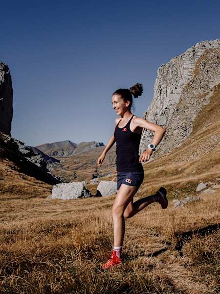 Uśmiechnięta biegaczka w górach