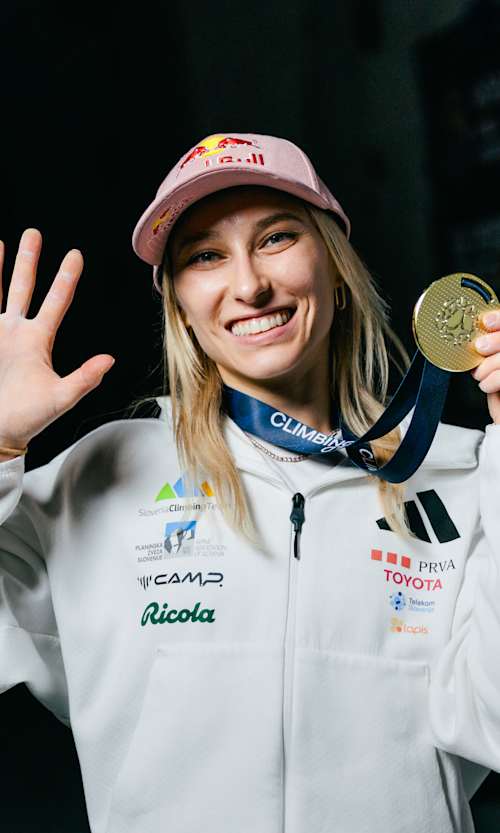In June 2026, Janja Garnbret celebrates her milestone 50th gold medal at the World Climbing Lead World Cup Final in Innsbruck, Austria, wearing her iconic Red Bull cap