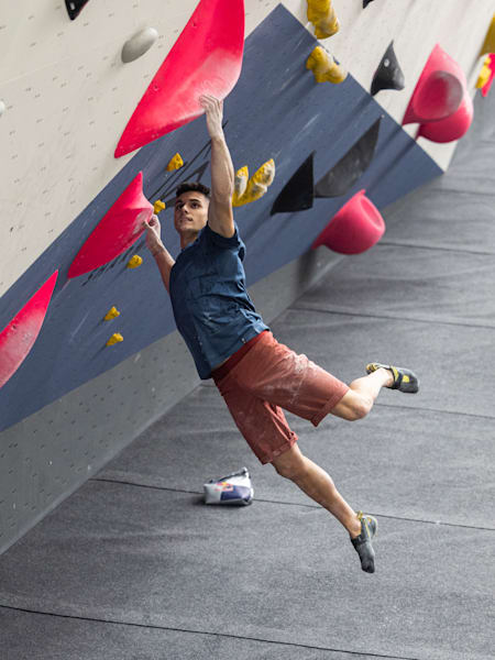 Alberto Gines Lopez grimpe un mur dans une salle d'escalade.