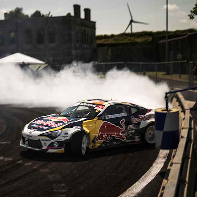 Conor Shanahan drifts his Red Bull car with precision on Spike Island, Cork, in 2025, surrounded by tyre smoke and high-octane excitement