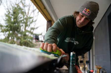 Benny Milam waxes his snowboard at Benny's Basecamp in St. Croix Falls, WI