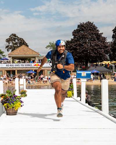 A participant runs down the dock to deliver mail at the 2025 Red Bull Rush Delivery event on Lake Geneva.