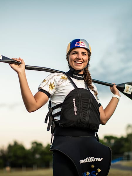 Jessica Fox stands with her kayak paddle over her shoulders.