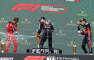 Max Verstappen, Charles Leclerc y Sergio Pérez celebran en el podio del Gran Premio de Austria de Fórmula 1 2023 en el circuito de Spielberg.