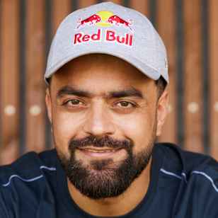 Rashid Khan Arman is seen in 2025 proudly wearing Red Bull apparel on a cricket field in Salzburg, Austria, capturing Red Bull's spirit of sporting adventure.