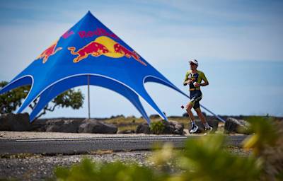Sebastian Kienle läuft während des IRONMAN an einer Energy Station vorbei.