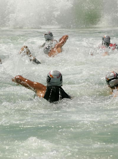 Swimmers battle whitewater and waves.
