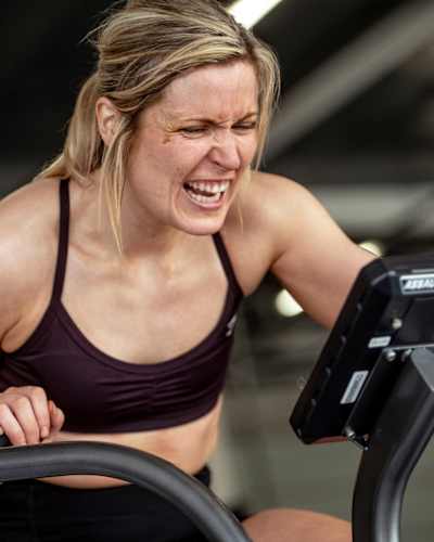 On 6th August 2025, a determined participant trains on a fitness bike at the Red Bull Pit Race during the Red Bull Hyrox coaches camp, Silverstone Circuit, UK, epitomising Red Bull energy