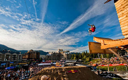 Un rider pose un Backflip Barspin pendant le Red Bull Joyride au Mountain Bike Park de Whistler au Canada.