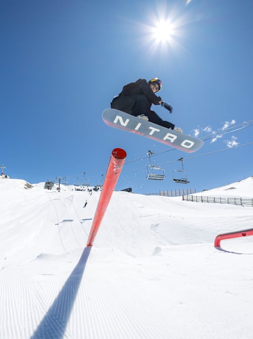 Cool Wakushima jumps from a rail feature in the snowboard park at Cardrona Alpine resort near Wanaka, New Zealand in October 2025 