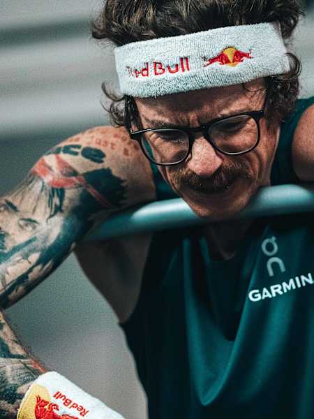 Ultrarunner Florian Neuschwander hängt völlig erschöpft über seinem Laufband, nachdem er den 100 km Weltrekord pulverisiert hat.