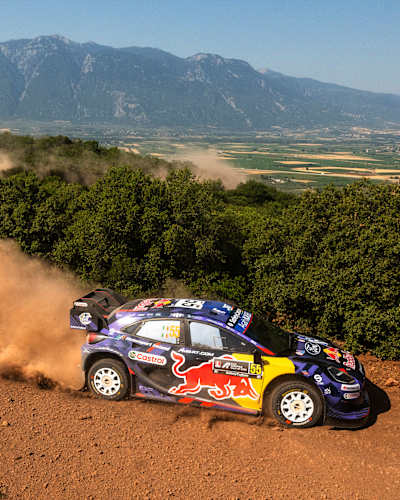 On June 26, 2025, Josh McErlean and M-Sport Ford World Rally Team race through the dusty terrain of Lamia during the World Rally Championship Greece, sporting Red Bull's iconic livery