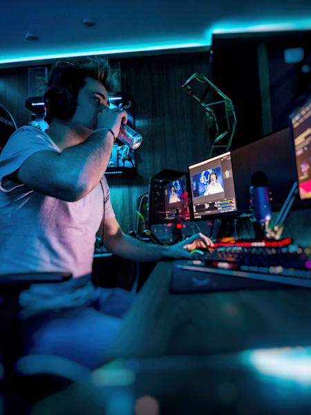 A gamer sips a can of Red Bull while streaming.