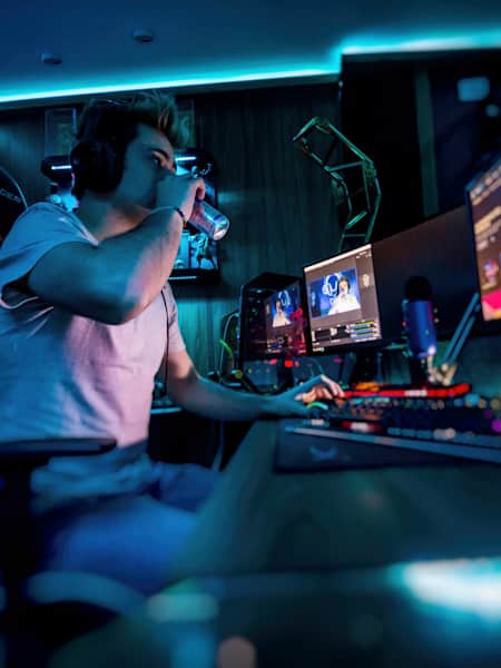 A gamer sips a can of Red Bull while streaming.