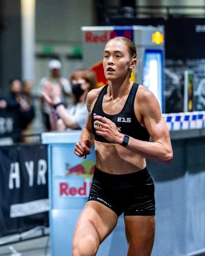 HYROX pro athlete and record holder Joanna Wietrzyk running past a stand with Red Bull 