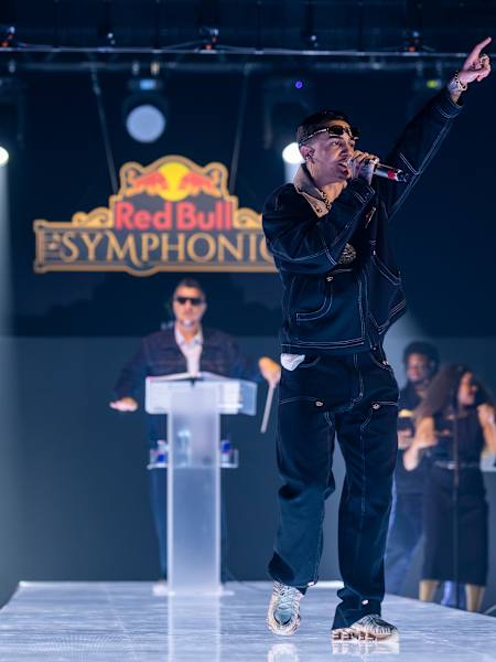 MC Hariel performs on stage during Red Bull Symphonic in São Paulo, Brazil, on 8 August 2026, backed by a live orchestra and bathed in dramatic blue lights.