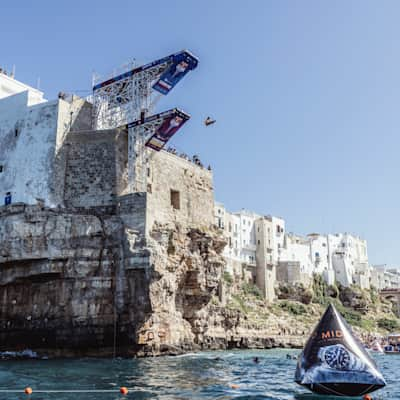 A cliff diver dives off a board in Poligniano a Mare, Italy.