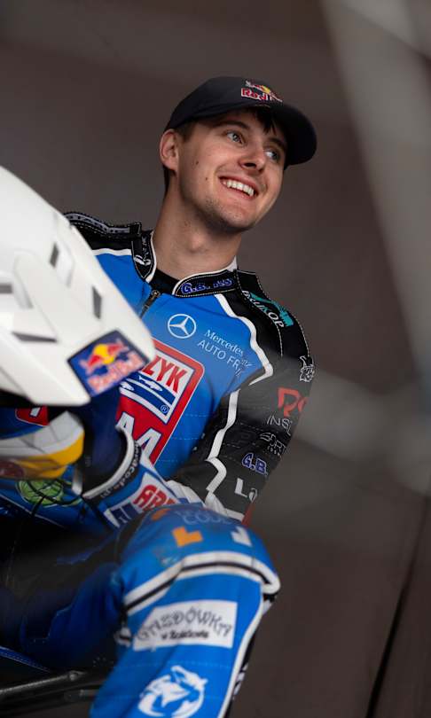 Wiktor Przyjemski smiles in his blue racing suit and Red Bull helmet in Toruń, Poland, April 2026