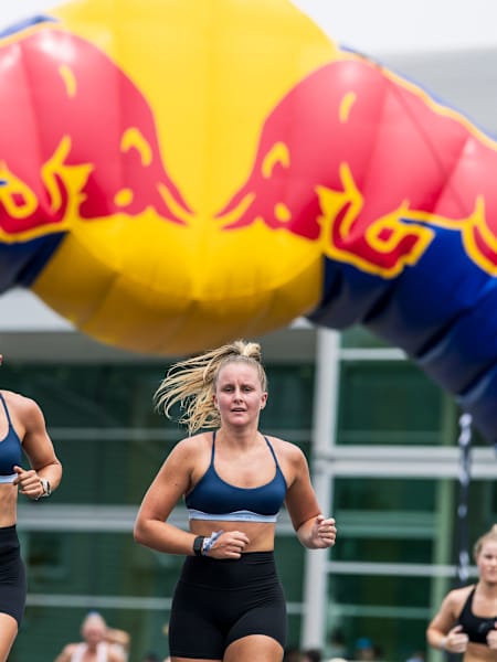 Two women running alongside each other at a HYROX fitness race