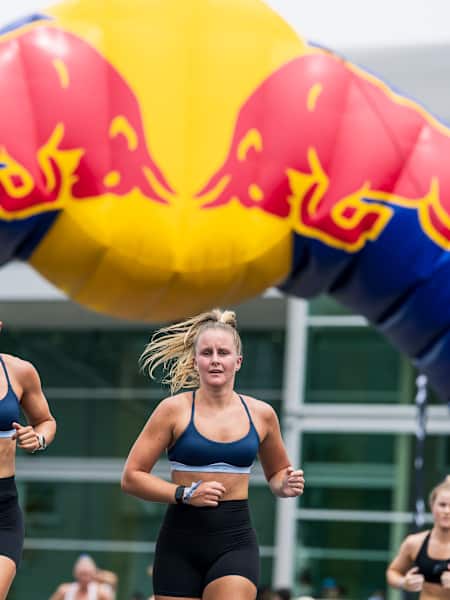 Two women running alongside each other at a HYROX fitness race