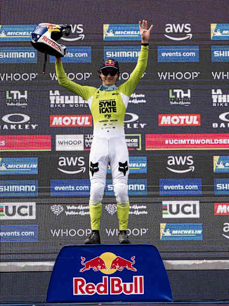 Jackson Goldstone celebrates his victory at the UCI Mountain Bike World Cup 2025 in La Thuile, Italy, raising his helmet on the podium.