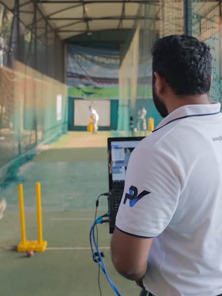 A person operates PitchVision's PV/One as players play on a pitch