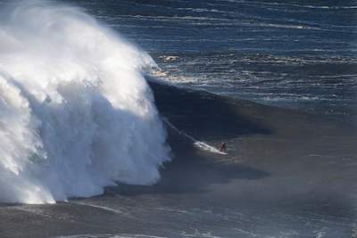 La Française Justine Dupont en action en surf sur les grosses vagues de Nazaré au Portugal.