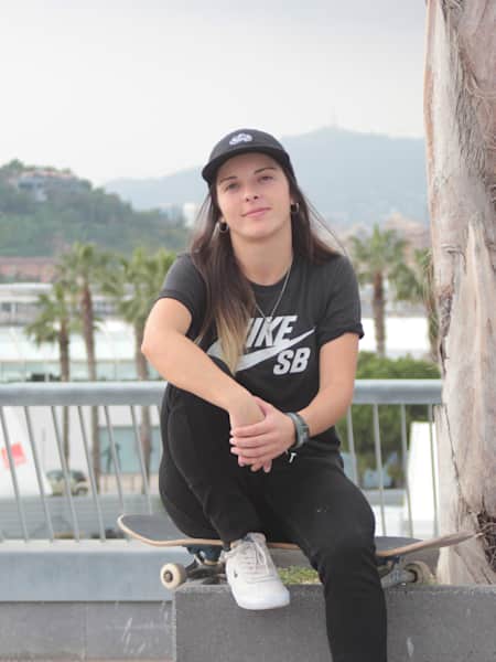 Melisa Ruiz, skater argentina, sentada sobre su tabla de skate con camiseta y gorra de Nike Sb.