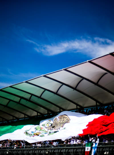 Una enorme bandera mexicana ondea sobre la grada durante el GP de México de Fórmula 1.