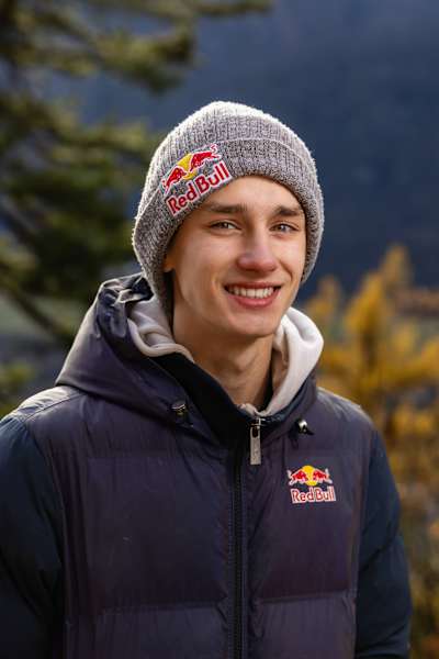 V roce 2025 Josef Šindel sebevědomě pózuje v oblečení Red Bull na pozadí podzimního Ticina ve Švýcarsku a zachycuje dobrodružného horského ducha značky.