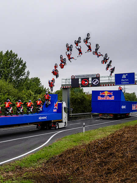 Luc Ackermann springt mit seinem FMX-Bike in Aldenhoven mit einem Tsunami Backflip über eine Höhenkontrolle. 