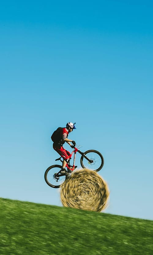 Le trialiste Danny MacAskill ride sur son vélo de trial sur une meule de foin en Écosse.