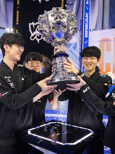 Winners Edward Gaming lift the trophy at the League of Legends World Championships 2021.