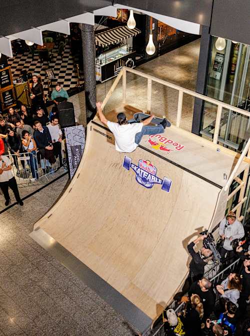 Im Jahr 2024 zeigt ein Skateboarder beim Red Bull Skateable-Event in Basel, Schweiz, Tricks, umgeben von einer energiegeladenen Menge