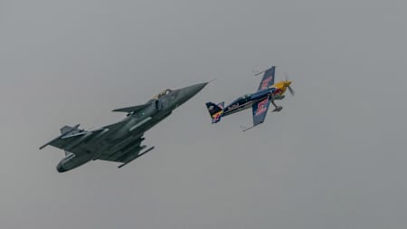 Una foto del campeón del mundo de la Red Bull Air Race, Martin Šonka, haciendo un tonel volado con su Extra 300SR sobre el caza Gripen del piloto Ivo Kardoš, de la Fuerza Aérea Checa.