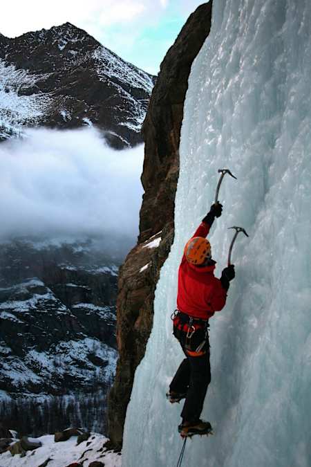 Ein Eiskletterer am gefrorenen Wasserfall in der Nähe von Cogne, im Aostatal, Norditalien, Europa.