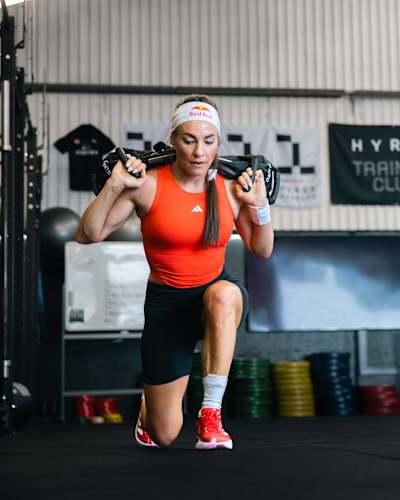 Dorothea Wierer doing sandbag lunges and training for a HYROX fitness race