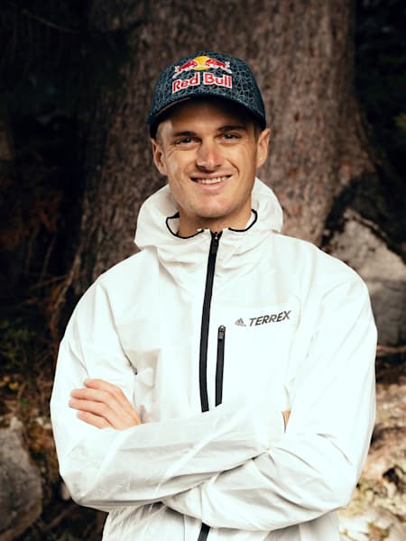 Anton Palzer mit Red Bull-Cap im Wald vor einem Baum.